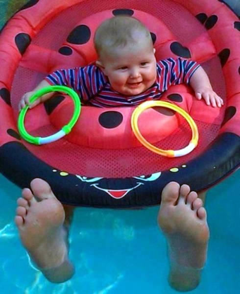 Baby im Pool Schwimmreifen mit riesigen Füßen 