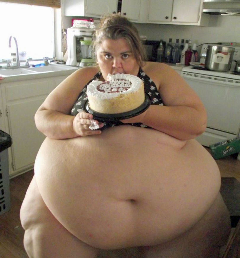 Fett Frau mit extremen Bauchumfang isst Torte in der Küche 