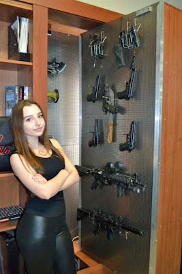 Junge Frau in Leggings zeigt Waffenschrank 