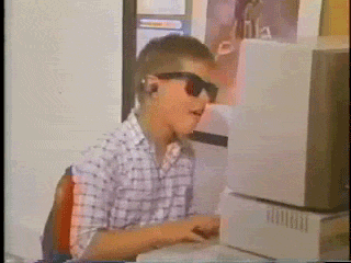 Kind mit Sonnenbrille vor Computer