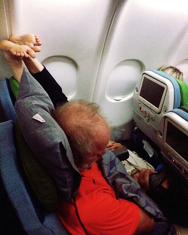 Lustig Füße hochlegen - beengt schlafen auf Boden vom Flugzeug