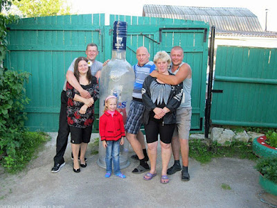 Familie posiert vor Kamera - Opa mit riesiger Wodka Flasche