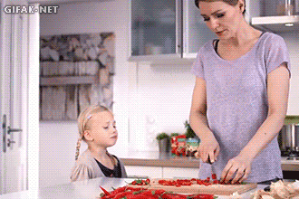 Lustige Hausfrau mit Kind in Küche beim kochen Hausfrau mit Kind in Küche beim kochen