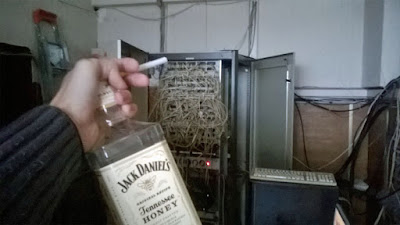 IT-Fachmann am Terminal Server Hub säuft Flasche Honig Whisky bei der Arbeit
