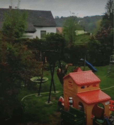 Lustiger Nachbar im Garten - Mit der Kinderspielplatz Schaukel überschlag machen