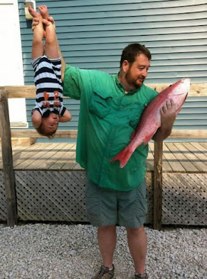 Vater hält Baby wie ein Fische hoch