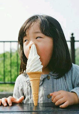 Kind beim Eis essen im Sommer
