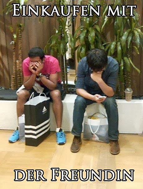 Männer warten im Shoppingcenter auf Freundin 