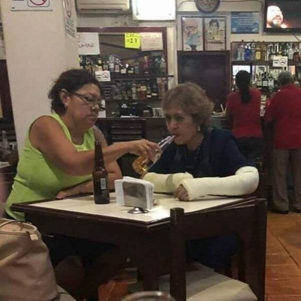 Mit zwei eingegibsten Armen in Bar einen trinken - Frauen mit Bier